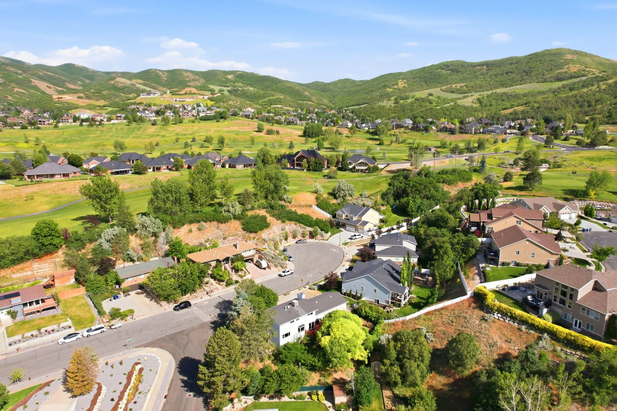 Residential community set against a backdrop of verdant hills and a golf course