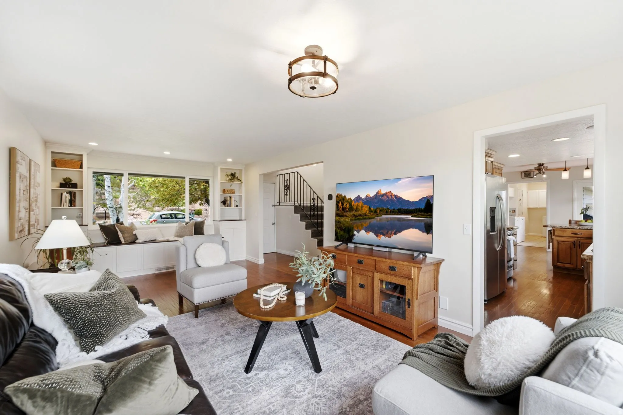 Living area featuring wood-finish flooring, recessed lighting, a window seat with built-in storage, and open shelving