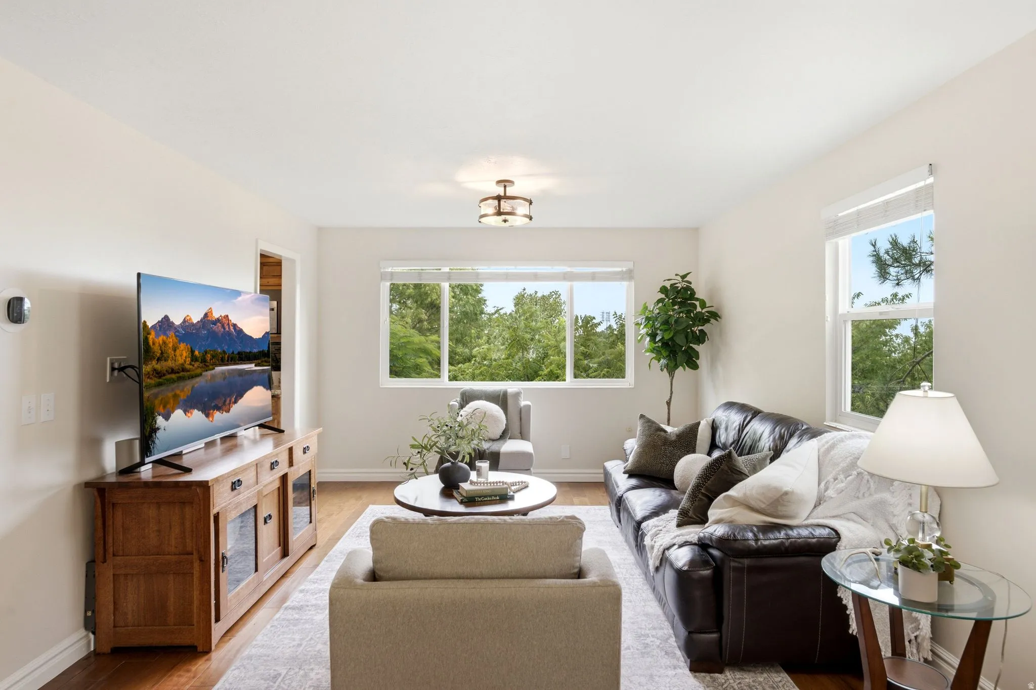 Living area featuring wood-finish flooring, light-toned walls, and multiple windows