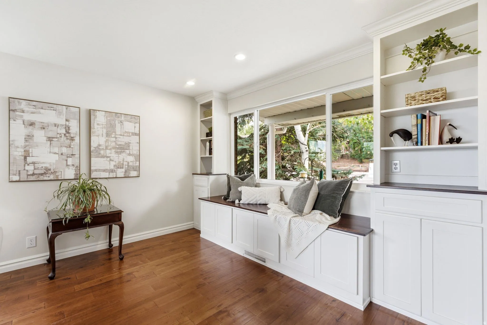 Built-in window seat with dark wood-finish top and panel-front cabinetry