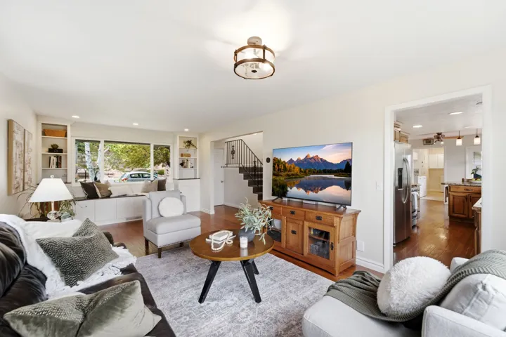 Living area featuring wood-finish flooring, recessed lighting, a window seat with built-in storage, and open shelving