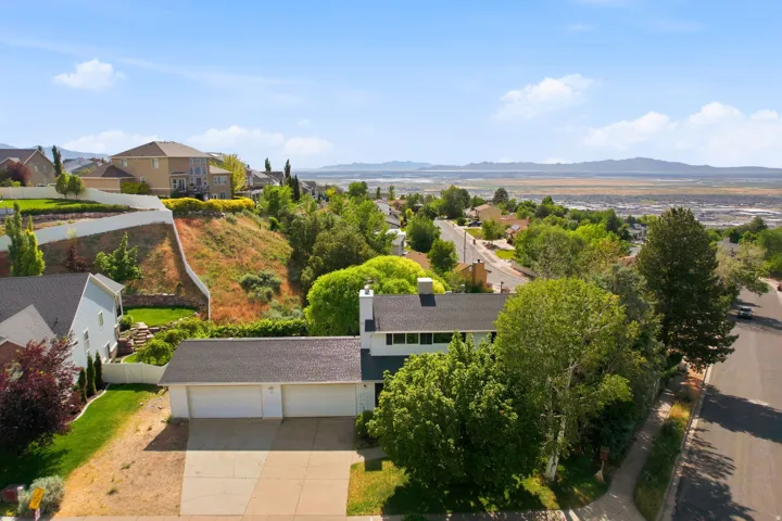 Aerial perspective showcasing a residential property with a multi-car garage and a paved driveway