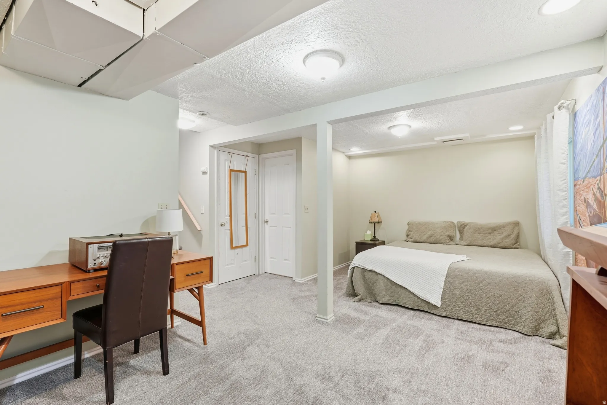 Finished lower level space featuring light gray carpeting, recessed lighting, a built-in architectural divide.