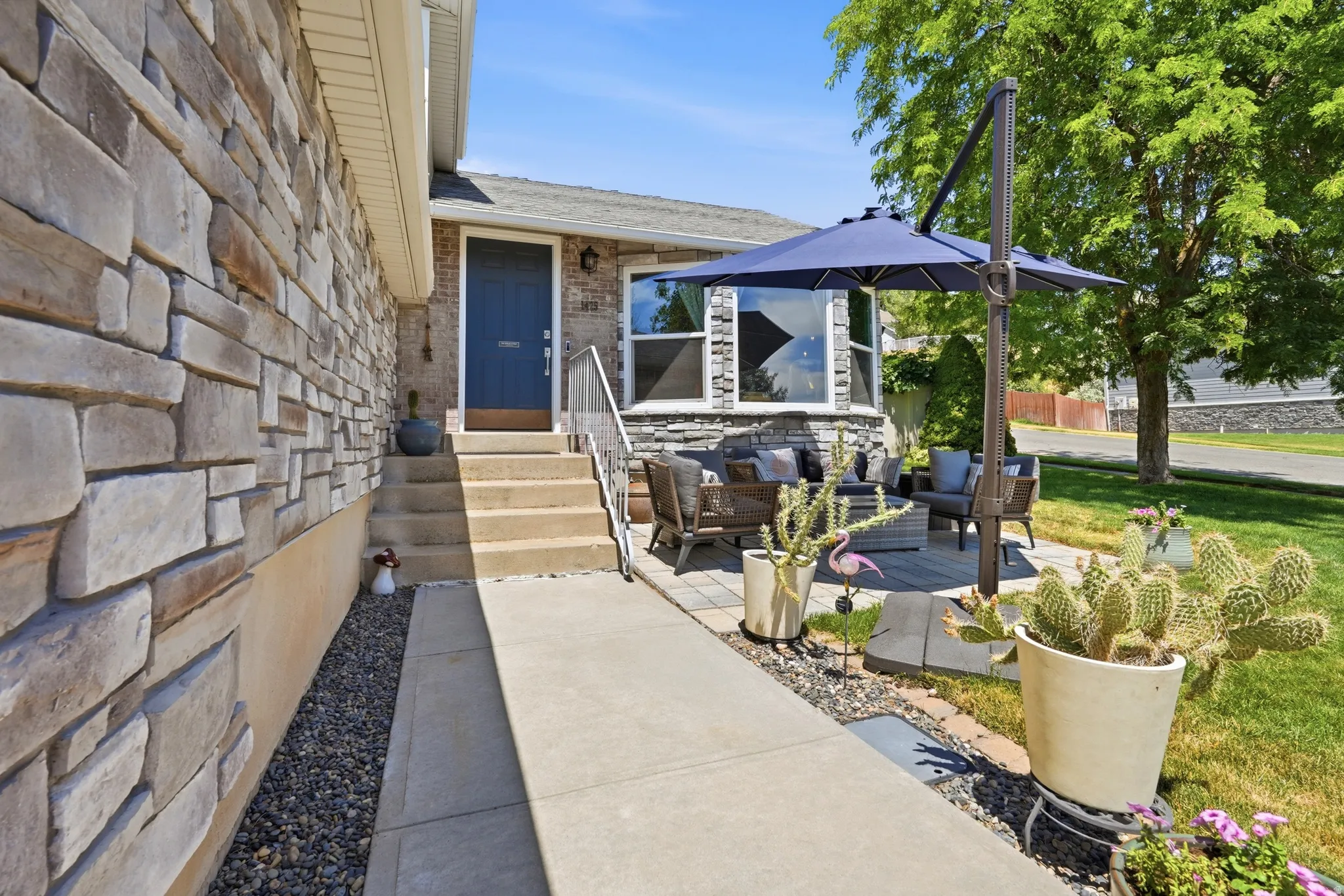 Stone veneer facade with a blue entry door and concrete steps