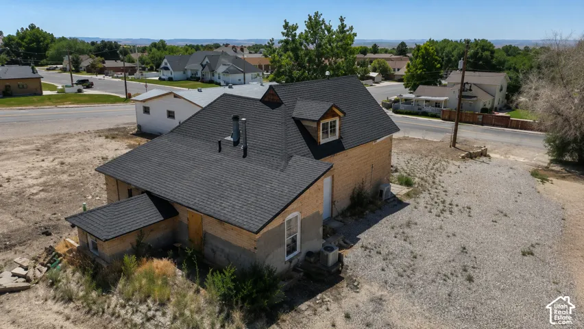 Newly installed dark shingle roof with dormer window detail, featuring a light-colored brick exterior