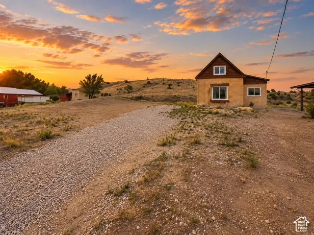 Gravel driveway leading to a residence with a stucco and wood-paneled exterior
