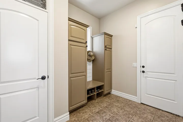 Functional Mudroom Connects the Garage, Laundry and Kitchen with Additional Built-In Cabinetry with Shaker-Style Doors, Integrated Bench Seating, and Shoe Storage