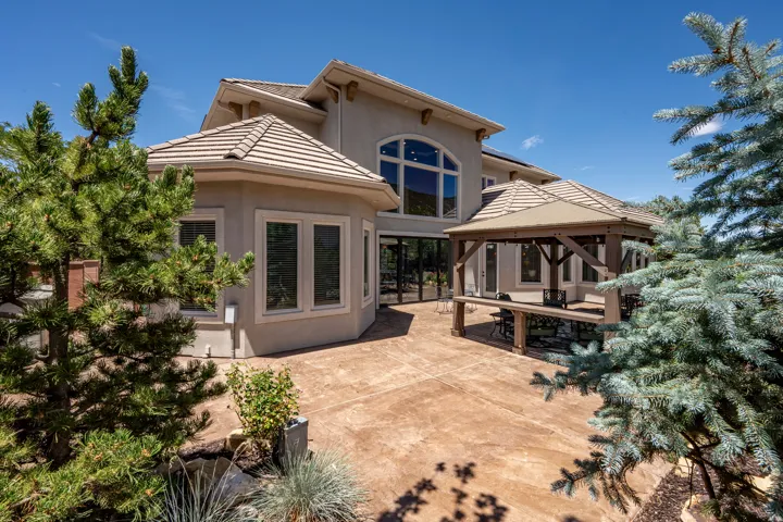 Rear Elevation Showcasing Indoor-Outdoor Living with Stamped Concrete Patio, Arched Transom Window Above the Stacking Doors
