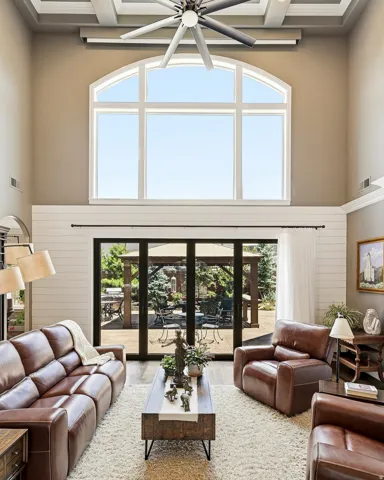 Indoor-Outdoor Living with a Skyhigh Coffer Ceiling, Two-Story Arched Transom Windows, Large Ceiling Fan,  and Shiplap Paneling