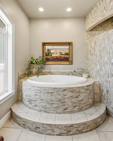 Luxurious Recessed Soaking Tub with Stone Tile Surround and Tiered Entry Steps for Ultimate Relaxation