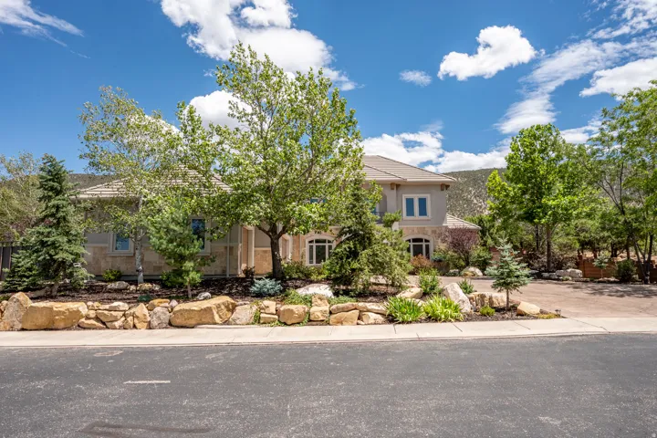 Mature Trees, Natural Landscaping, Stong Retaining Wall and an Expansive Stamped Concrete Driveway, Enhance the Private Setting
