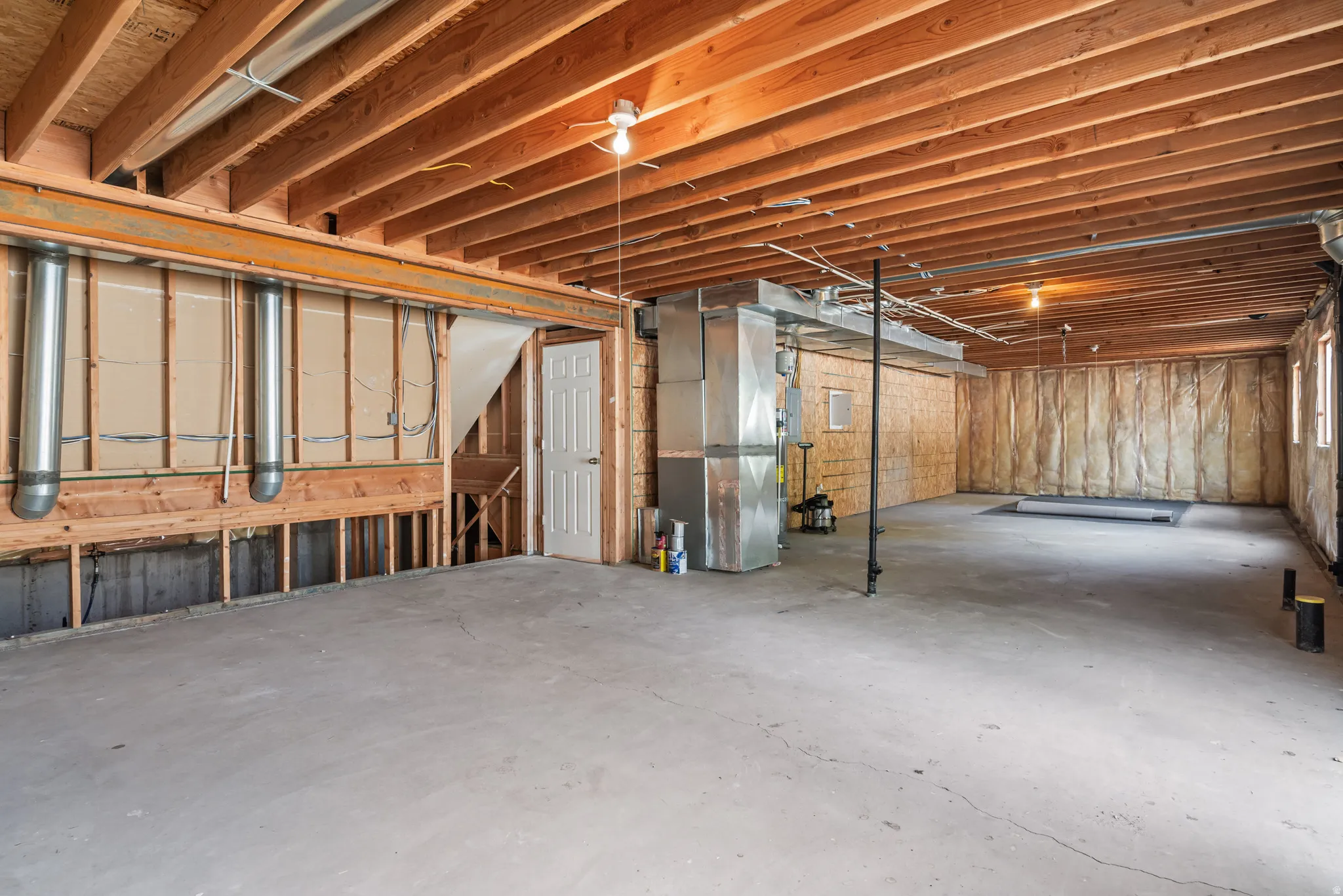 Unfinished basement featuring exposed wood joists, concrete flooring, and visible ductwork