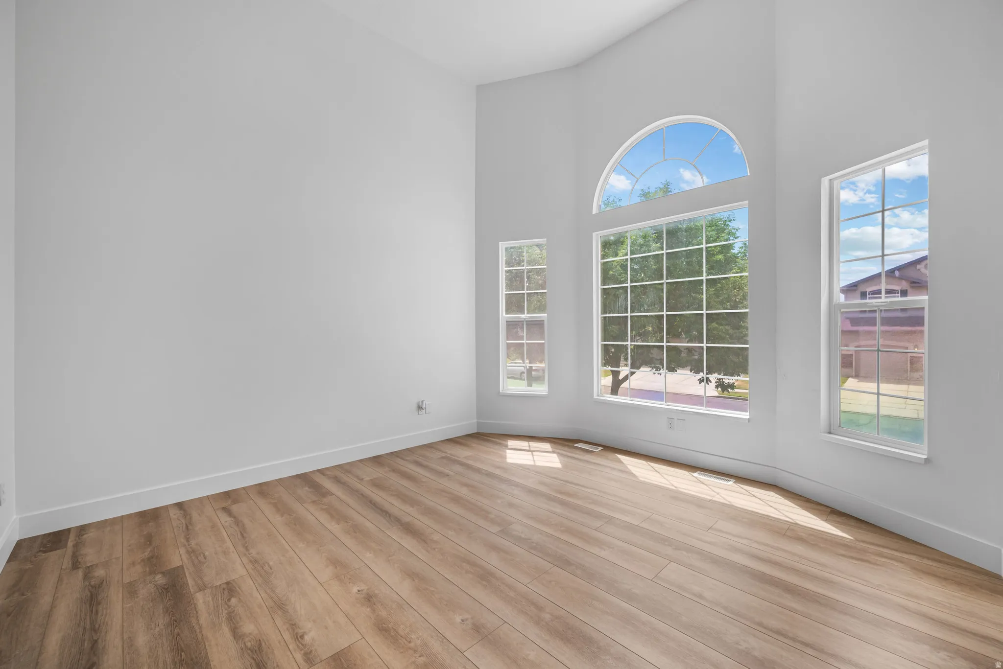 Expansive room featuring multiple windows, including a large arched transom window