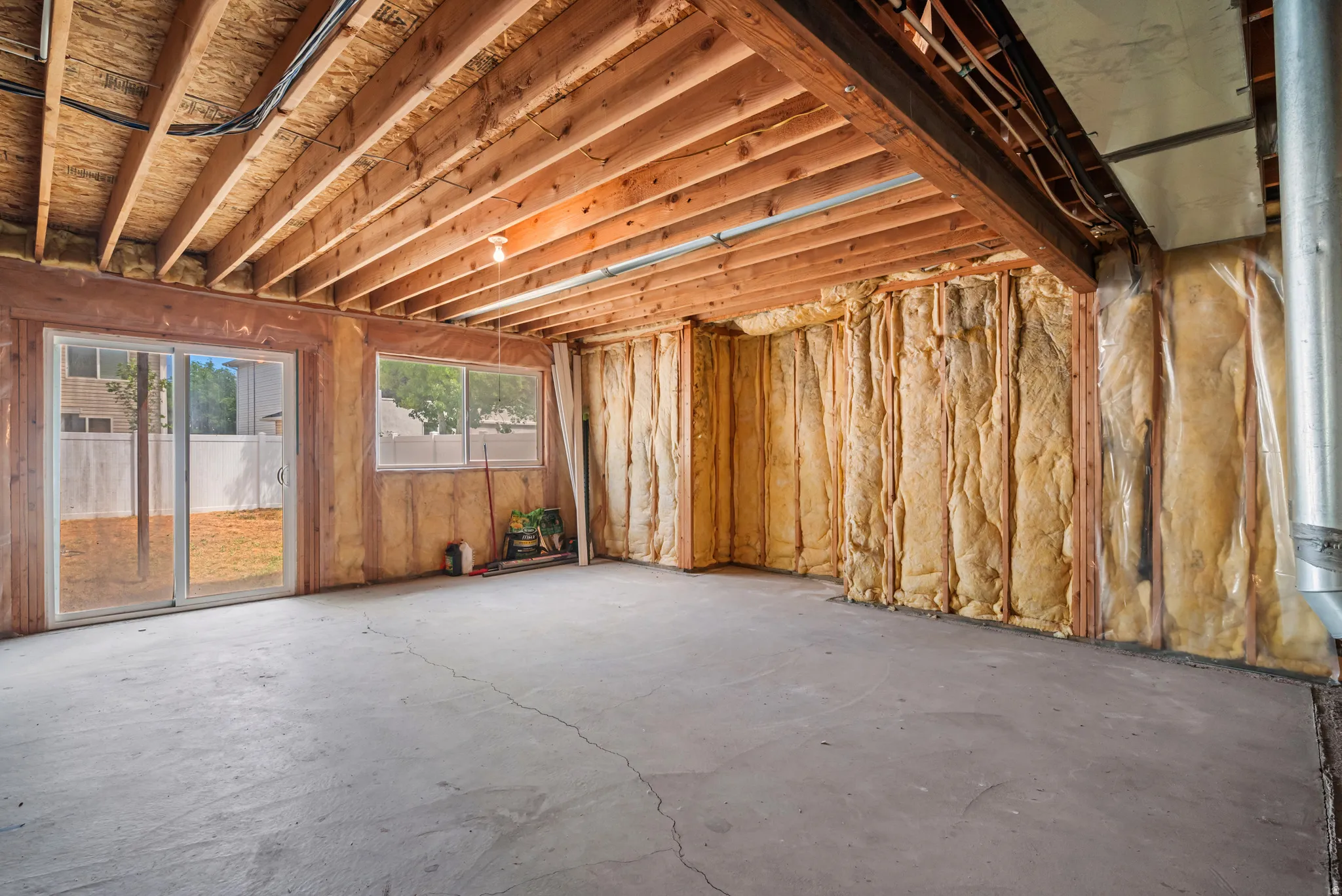 Unfinished basement with exposed wooden joists and concrete flooring
