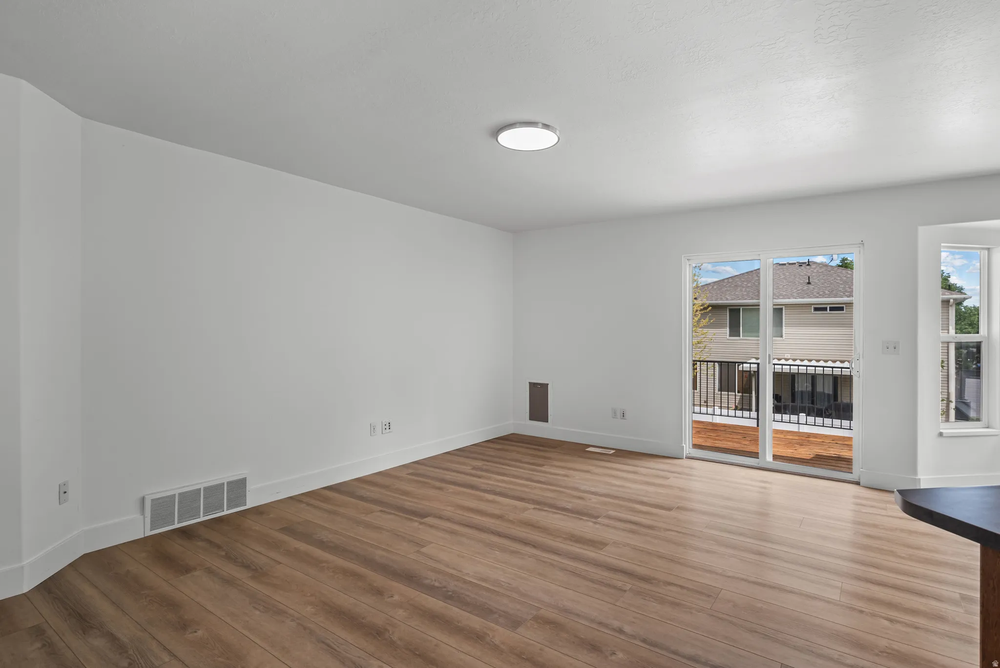 Spacious room featuring wood-finish flooring and bright white walls