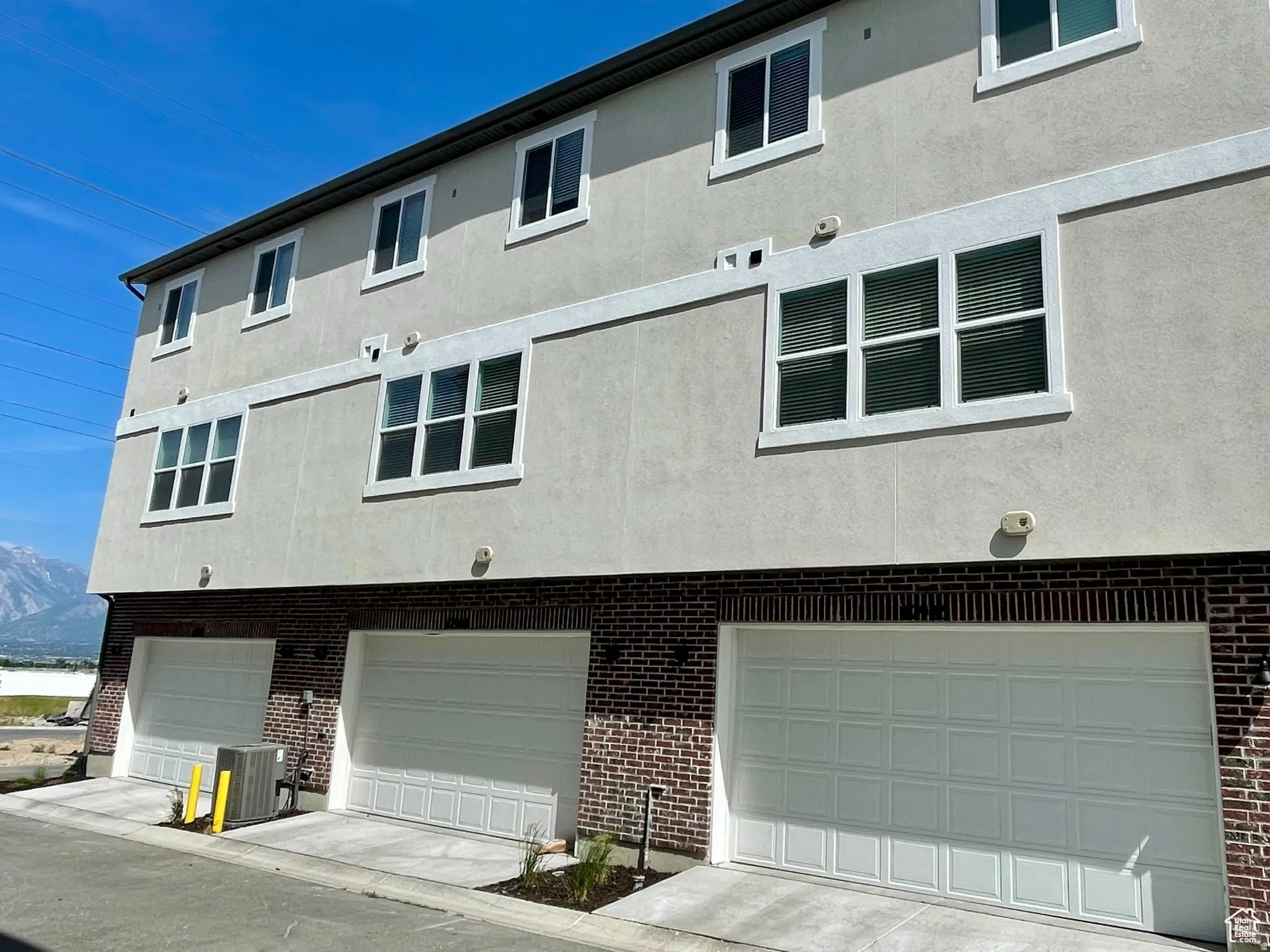 Modern multi-story building featuring a stucco exterior and brick accents