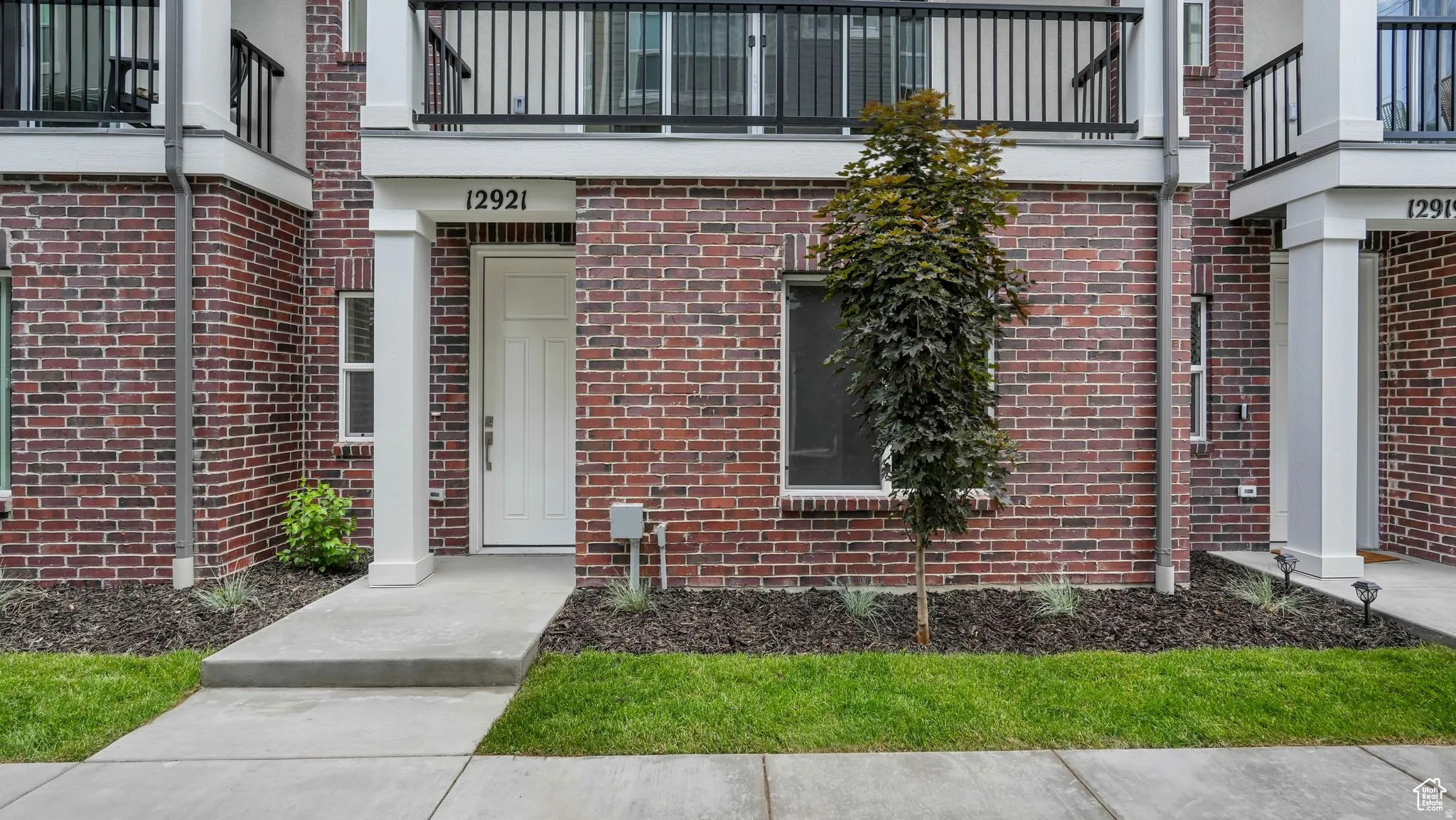 Brick facade with white trim and a prominent white entry door