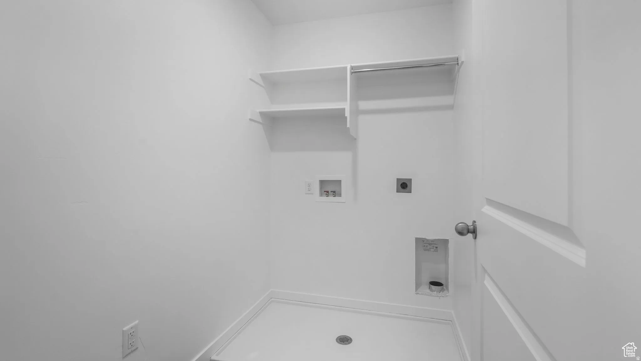 Dedicated utility room featuring white walls and a white floor