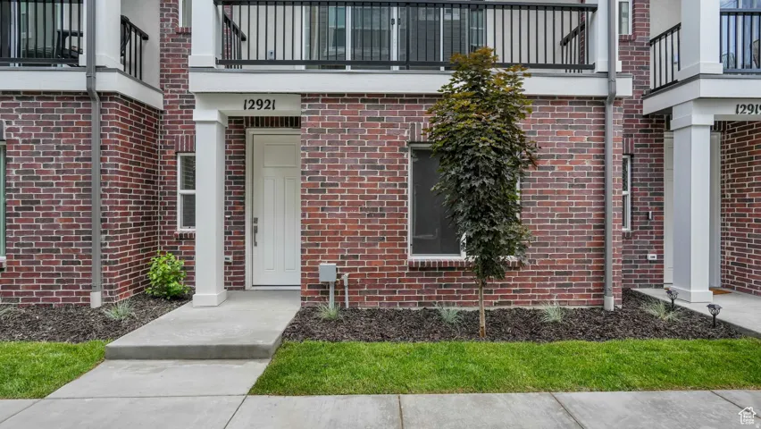 Brick facade with white trim and a prominent white entry door