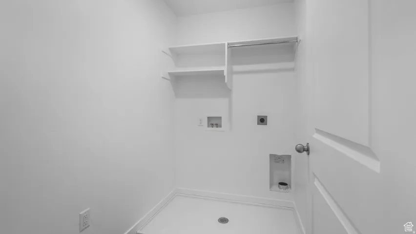 Dedicated utility room featuring white walls and a white floor
