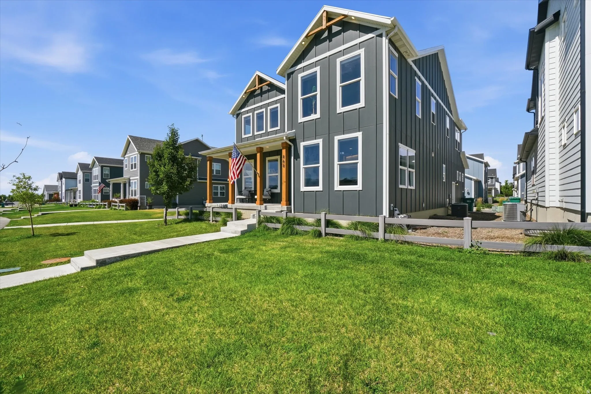 Modern farmhouse-style exterior with dark gray vertical siding and white trim
