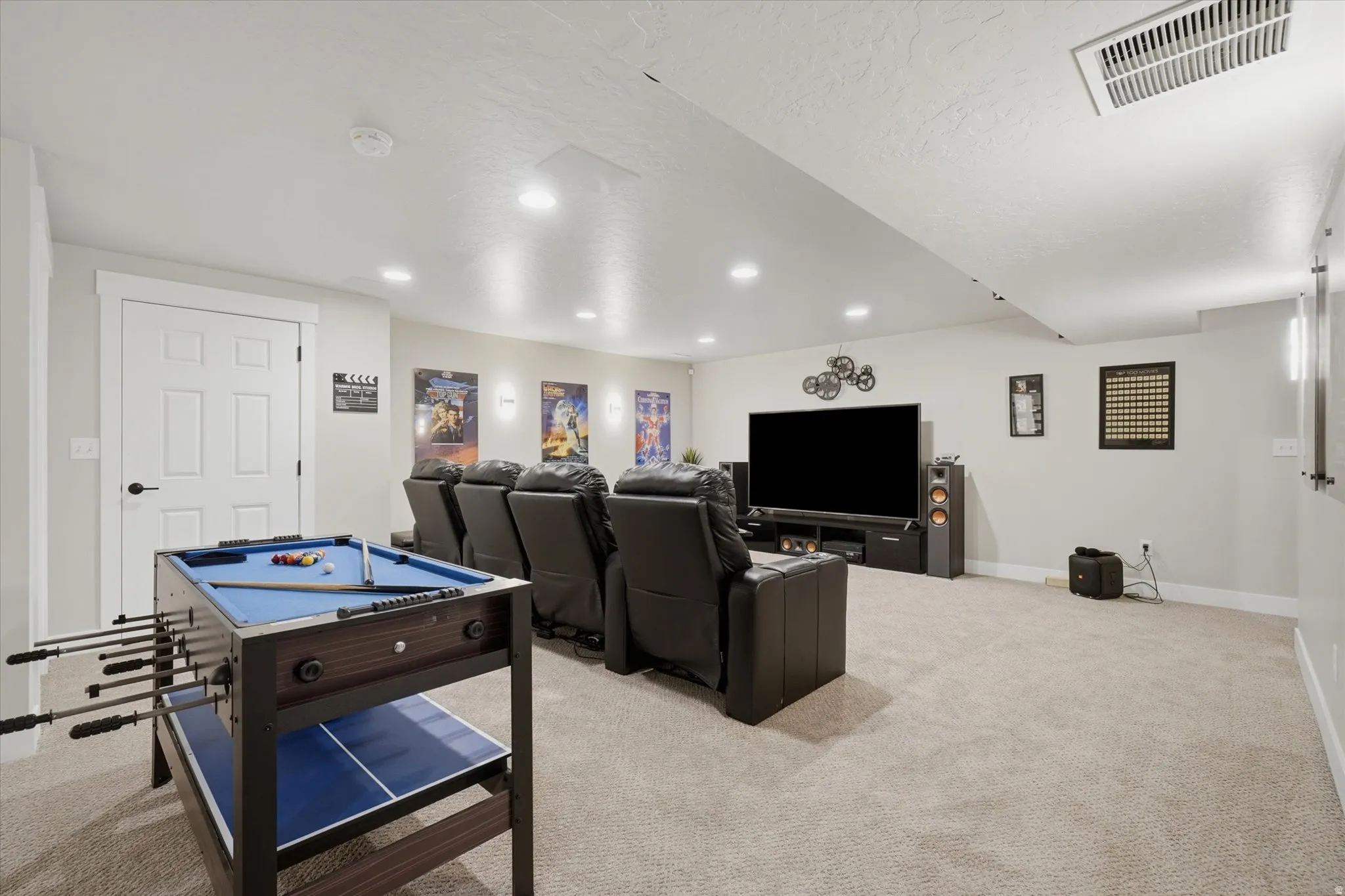 Spacious entertainment area with neutral carpeting and recessed lighting