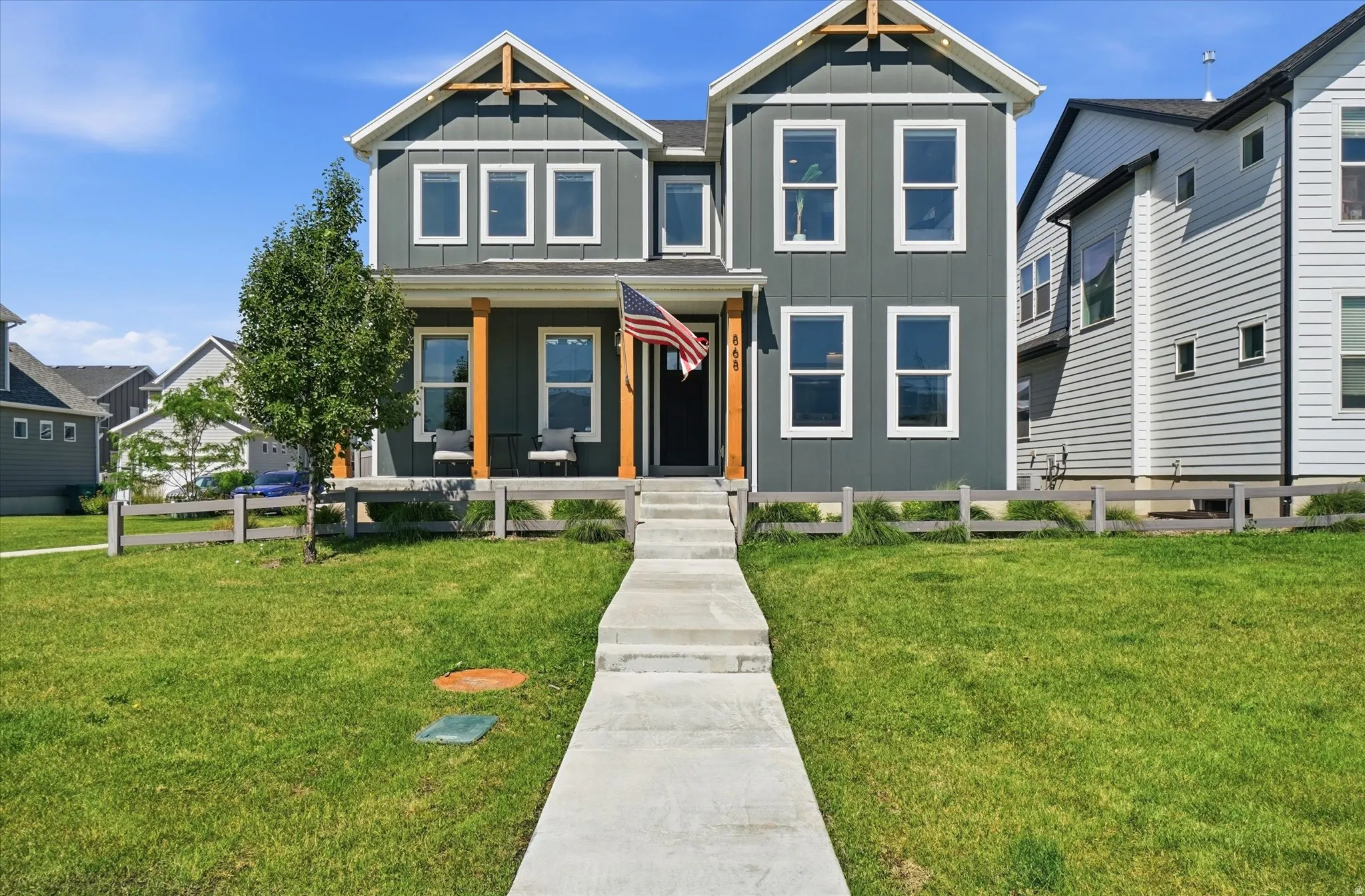 Modern two-story home featuring dark gray vertical siding with white trim accents