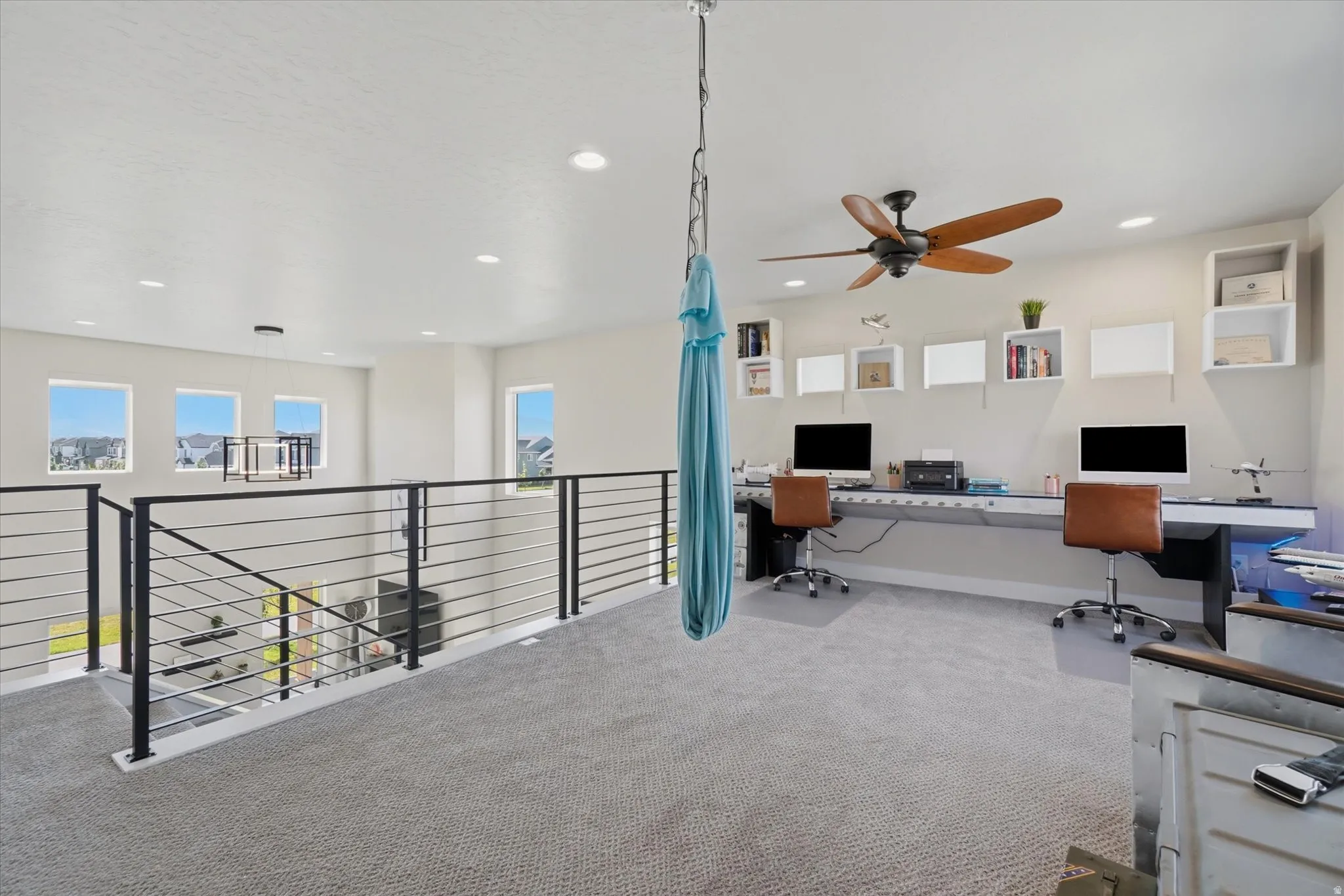 Expansive loft space featuring plush carpeting, recessed lighting, and a ceiling fan