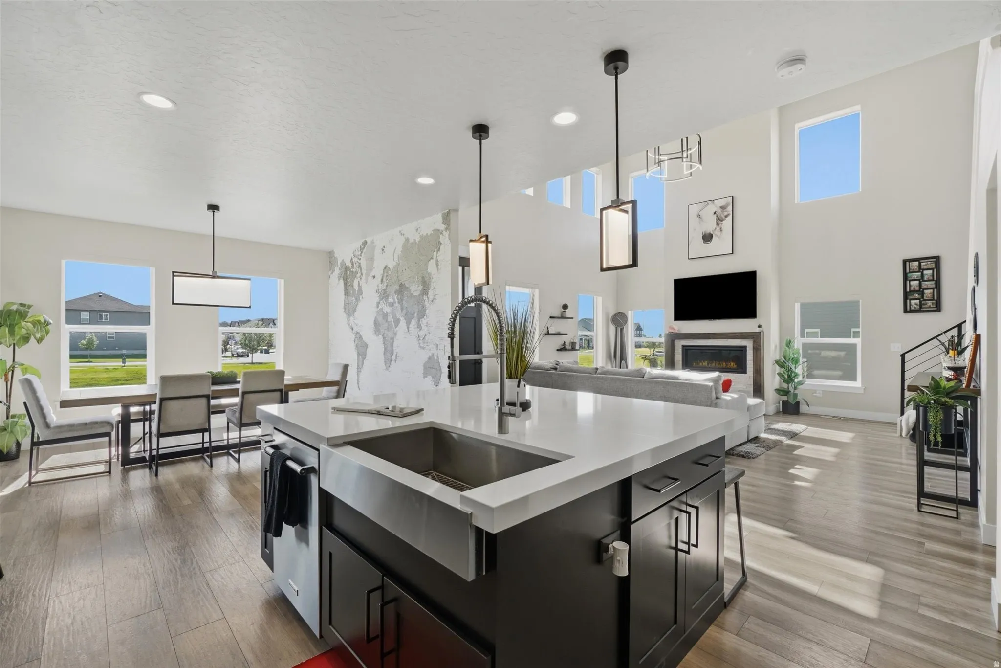 Kitchen island with a farmhouse sink, white countertop, and dark cabinetry