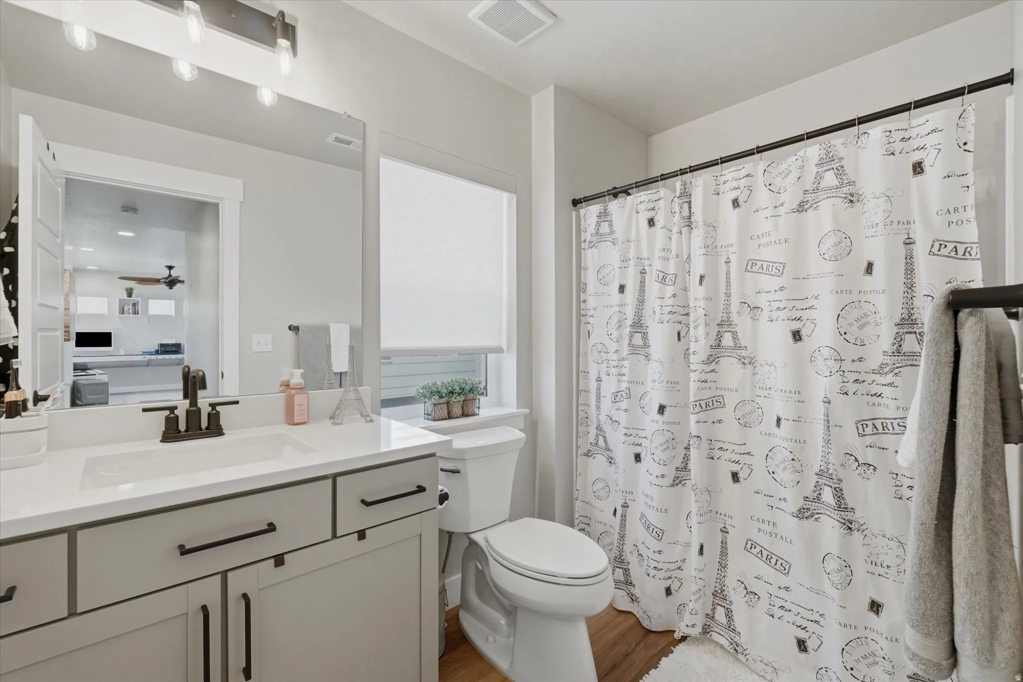 Bathroom featuring a single vanity with dark hardware, a white countertop, and a built-in sink