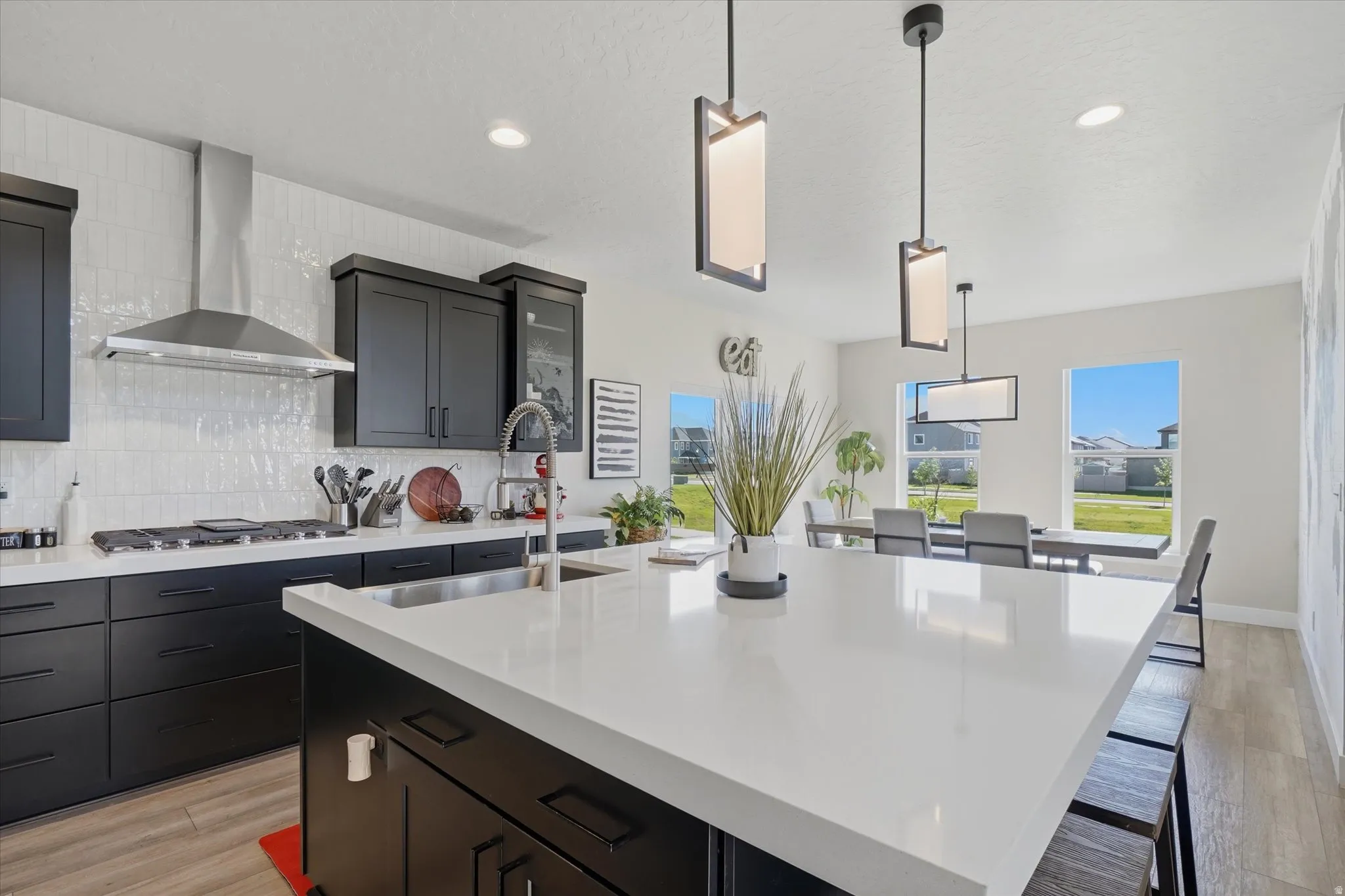 Modern kitchen featuring an expansive island with a white countertop and seating for dining