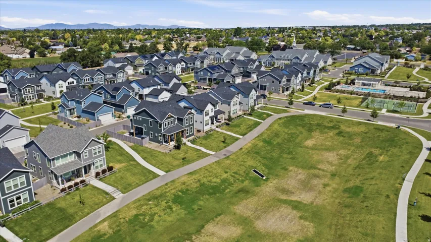 Residential development featuring a variety of home styles, green spaces, and a community pool