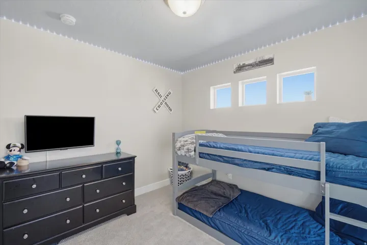 Room featuring three distinct rectangular windows providing natural light, light-toned wall finishes, and a flush-mount ceiling light fixture