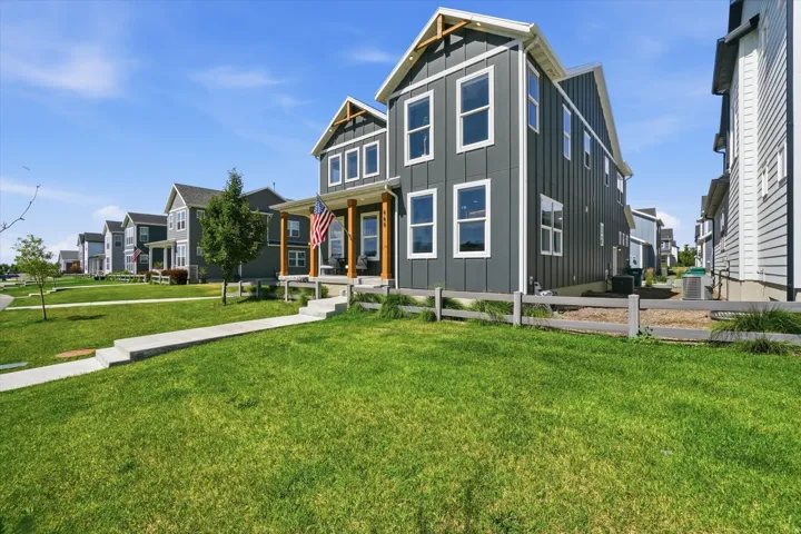 Modern farmhouse-style exterior with dark gray vertical siding and white trim