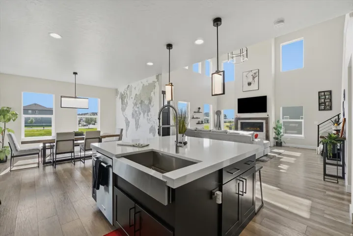 Kitchen island with a farmhouse sink, white countertop, and dark cabinetry