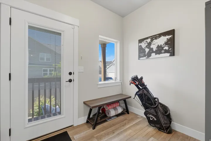 Entryway featuring a full-light glass door, wood-finish flooring, a single window, white trim, and light-toned walls