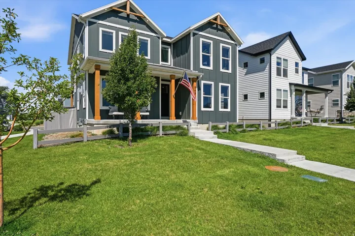 Contemporary two-story residence with dark gray vertical and horizontal siding, white trim, and a black shingled roof