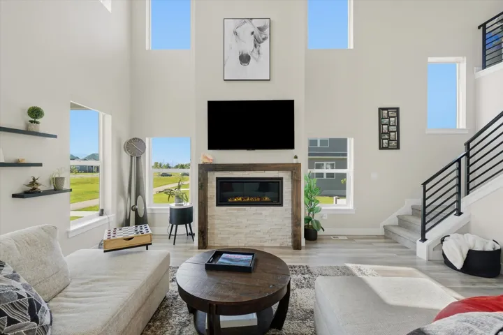 Living area featuring a floor-to-ceiling fireplace with a stacked stone facade and wood-frame surround