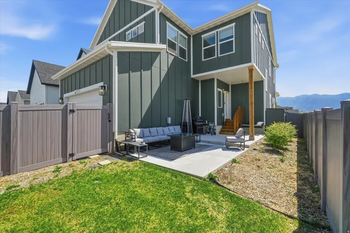 Rear exterior featuring a board and batten facade, private concrete patio, and fenced backyard