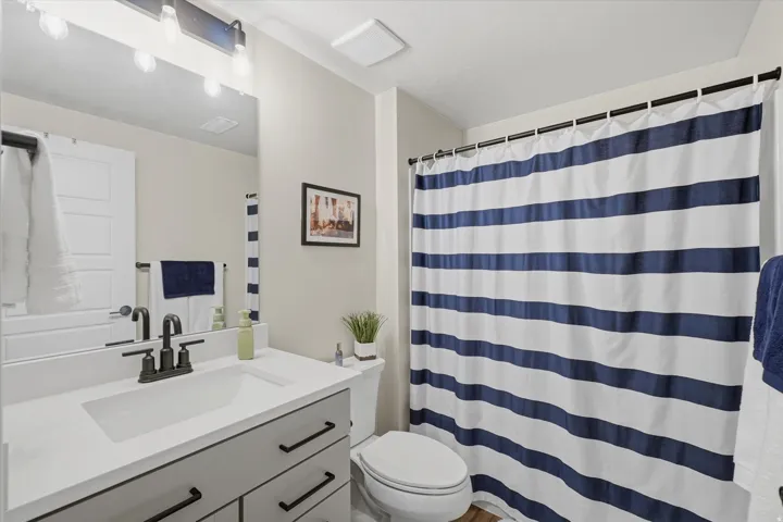 Bathroom featuring a single vanity with a white countertop and rectangular undermount sink, matte black faucet, and a large mirror