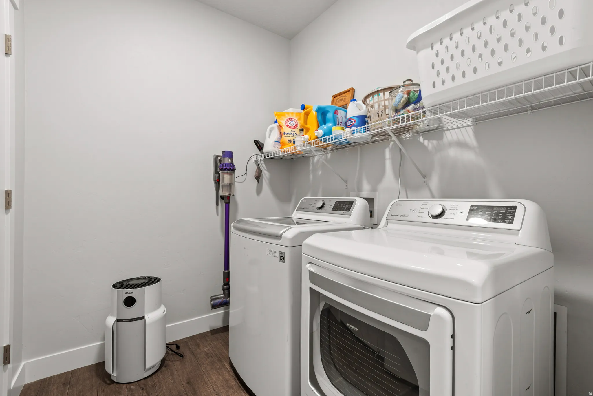 Dedicated laundry area featuring modern appliances and a wire shelving system