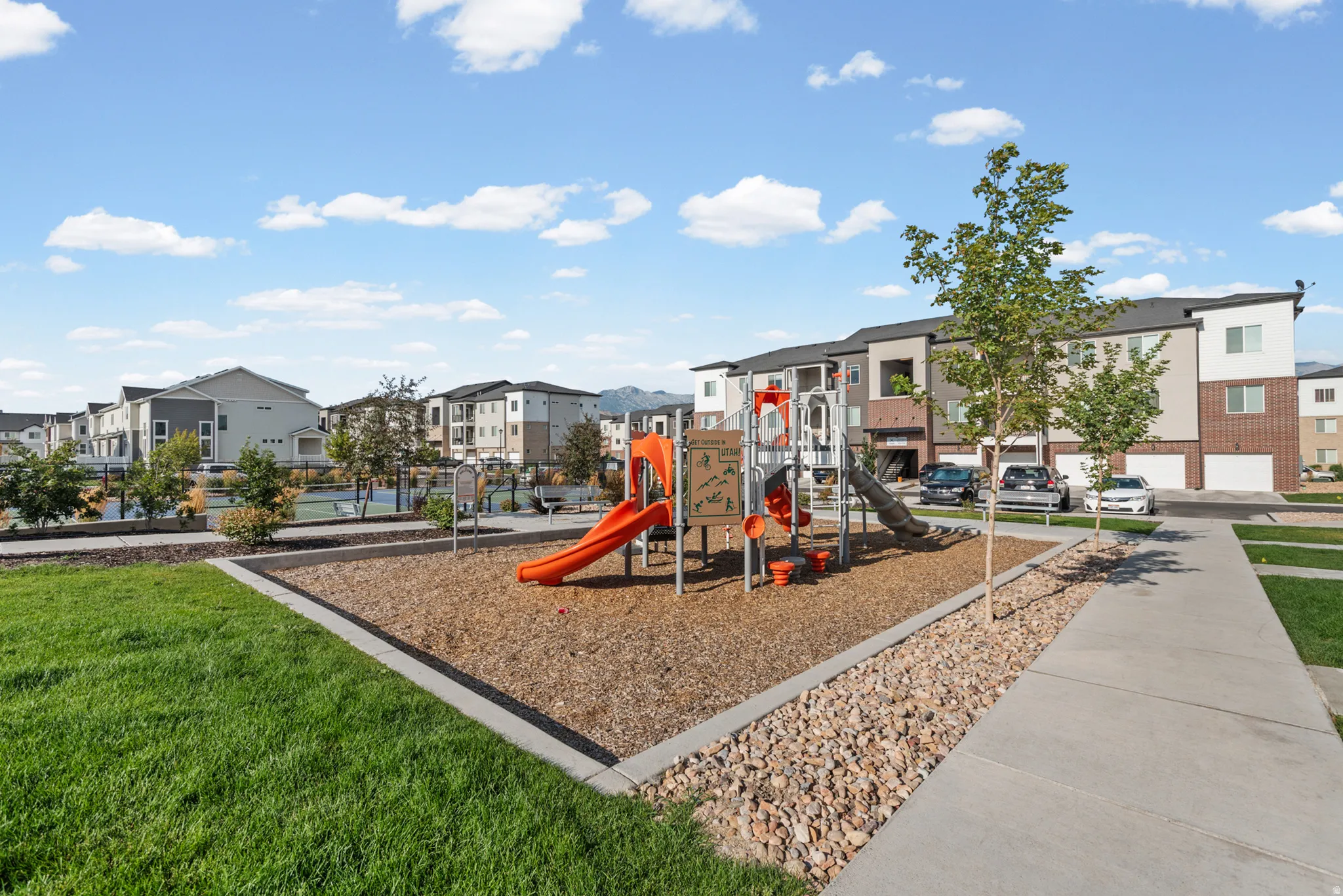 Community playground featuring slides, climbing structures, and a wood chip surface