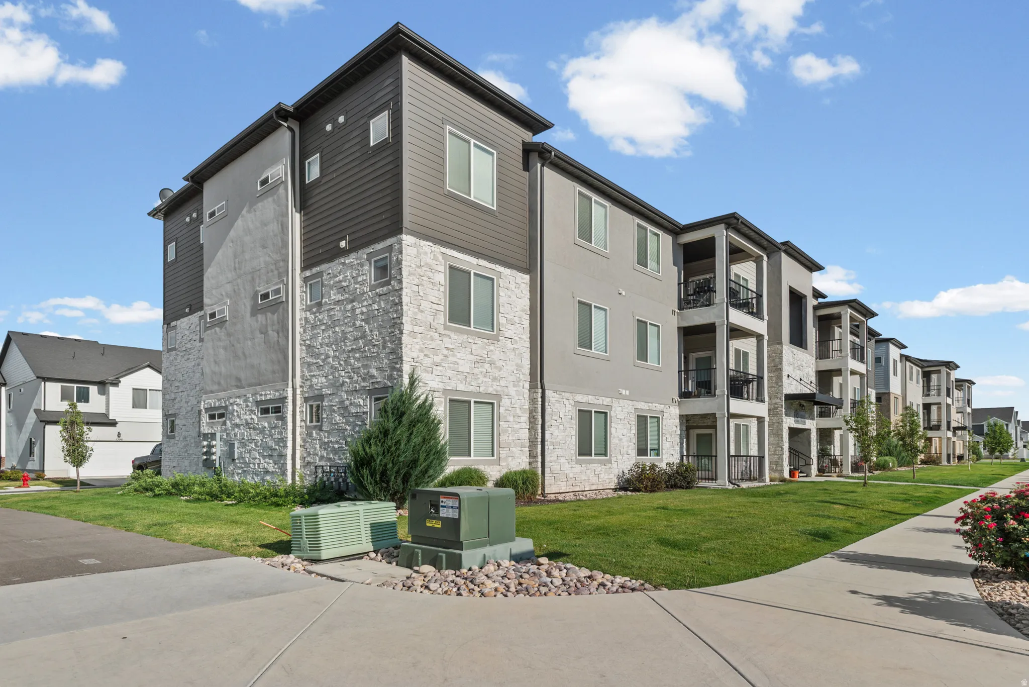 Modern multi-story building featuring stone veneer and horizontal siding