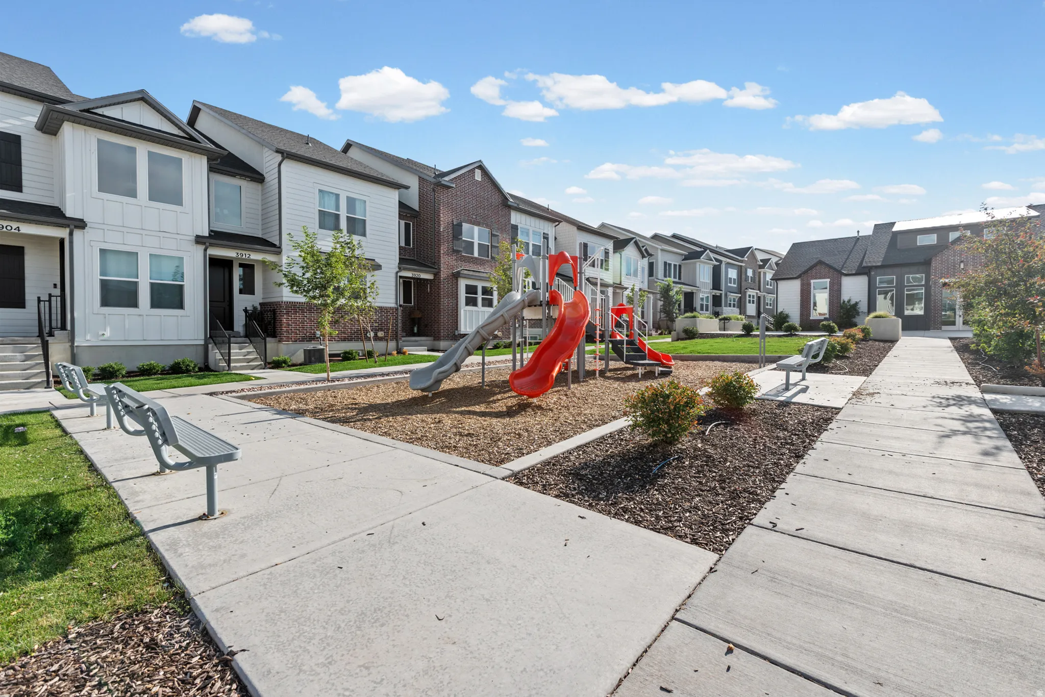 Community playground featuring slides and climbing elements set on a wood chip surface