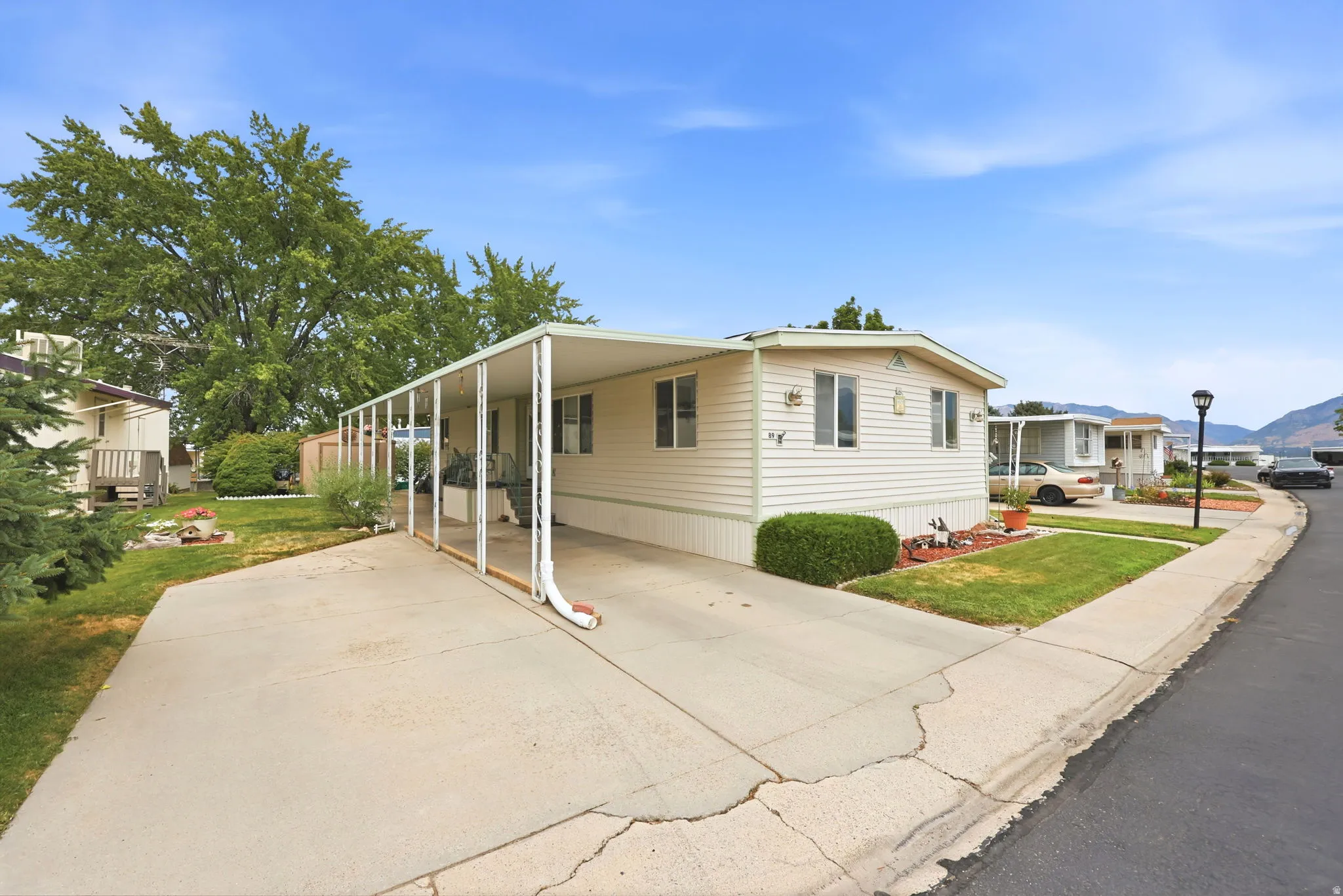 Cream-colored manufactured home with white trim and a covered carport