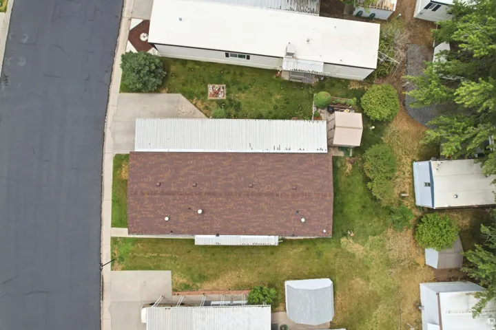 Brown shingle roof with white trim, situated on a grassy lot