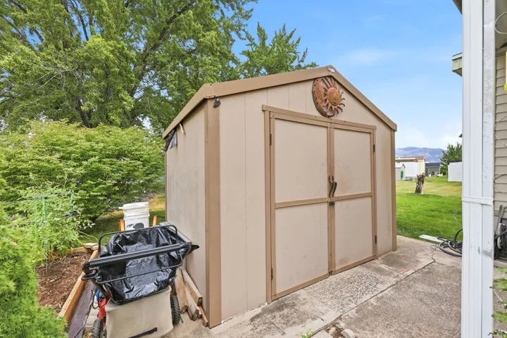 Exterior storage shed with double doors, pitched roof, and a concrete pad base