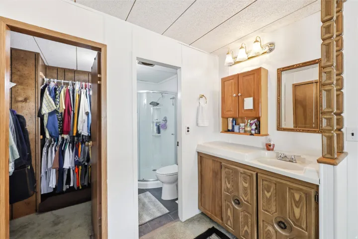 Bathroom featuring a wood-finish vanity with an integrated sink, a matching medicine cabinet, and a framed mirror