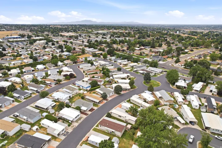 Residential community featuring paved streets, individual homes, and mature trees