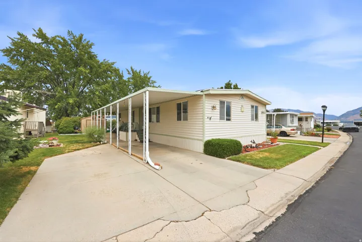Cream-colored manufactured home with white trim and a covered carport